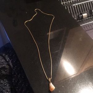 Long gold necklace with stone